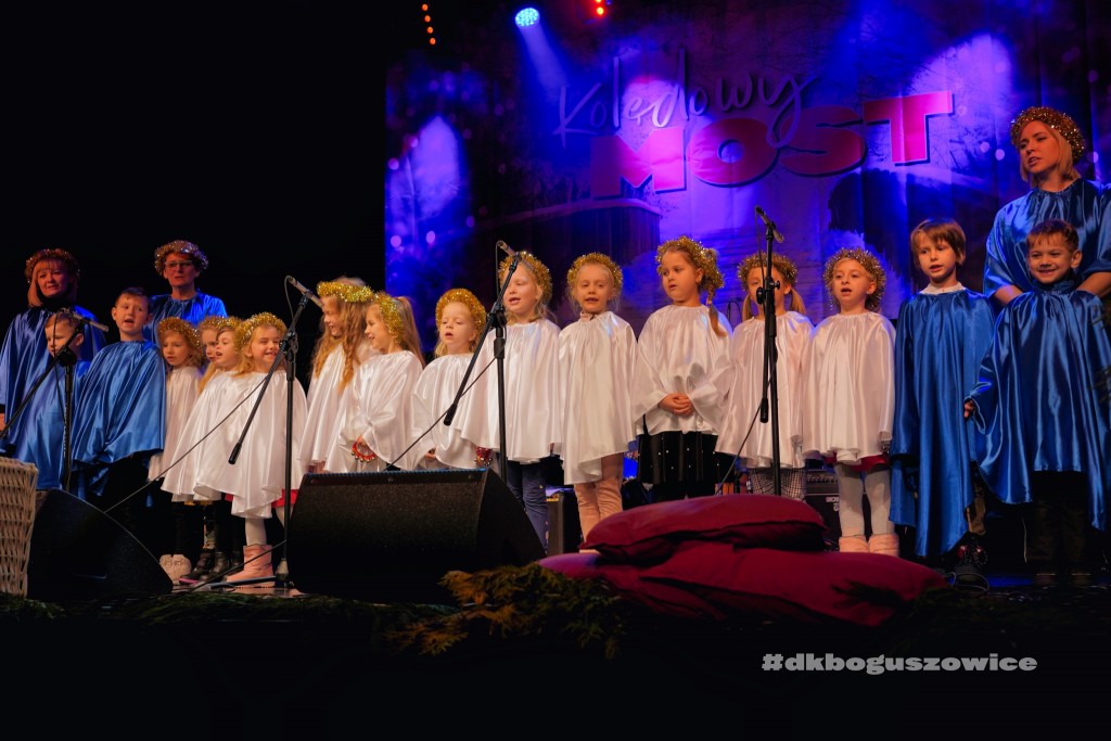 dzieci w białych szatach i złotych wiankach na scenie w DK Boguszowice
